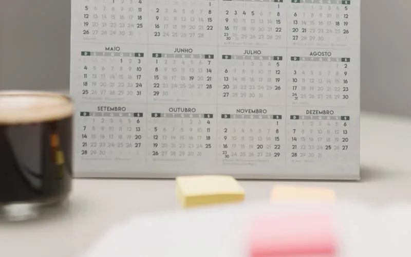 Planner aberto sobre mesa com calendário anual de promoções para salão