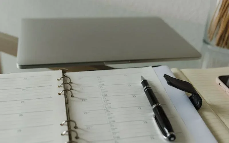 Caderno de gestão aberto sobre balcão de salão de beleza com caneta e calculadora