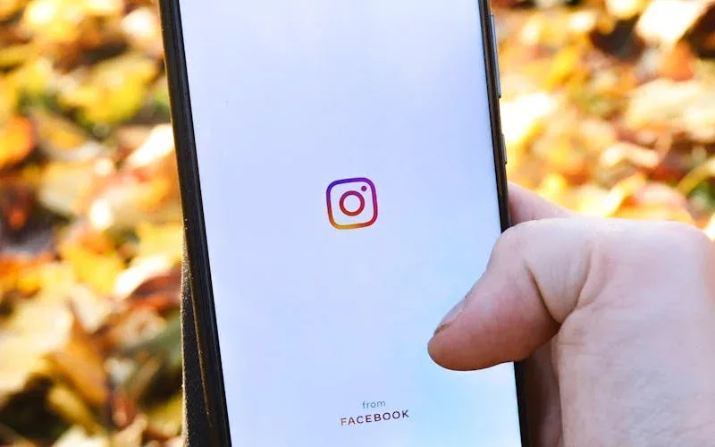 Profissional de beleza fotografando resultado de atendimento com smartphone em salão iluminado